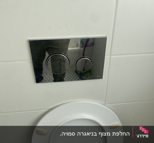 לחצן הדחה כפול על קיר מעל אסלה